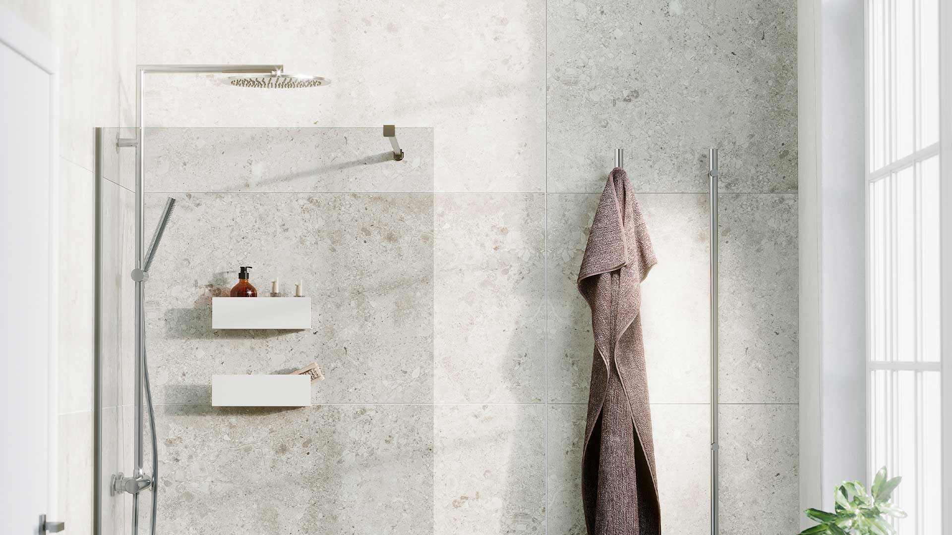 To rektangulære vegghyller Ledge i hvit, for praktisk oppbevaring i dusjen, sammen med Asti takdusj og Spirit dusjvegg i klarglass. 